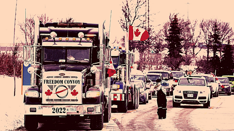 Foto de pessoas em uma manifestação dentro de carros e caminhões, com bandeiras canadenses.
