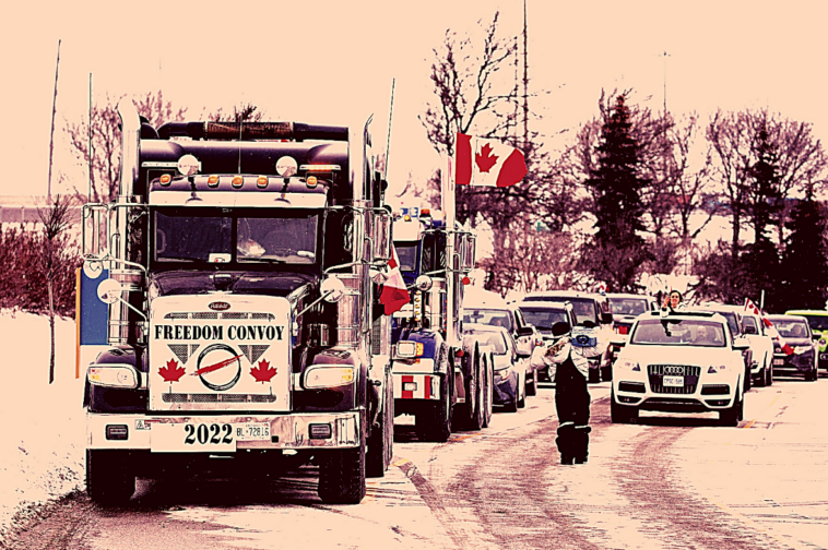 Foto de pessoas em uma manifestação dentro de carros e caminhões, com bandeiras canadenses.
