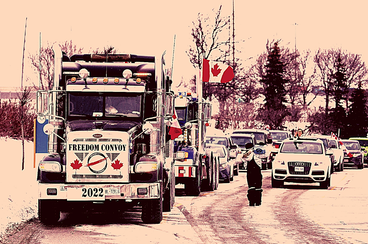 Foto de pessoas em uma manifestação dentro de carros e caminhões, com bandeiras canadenses.